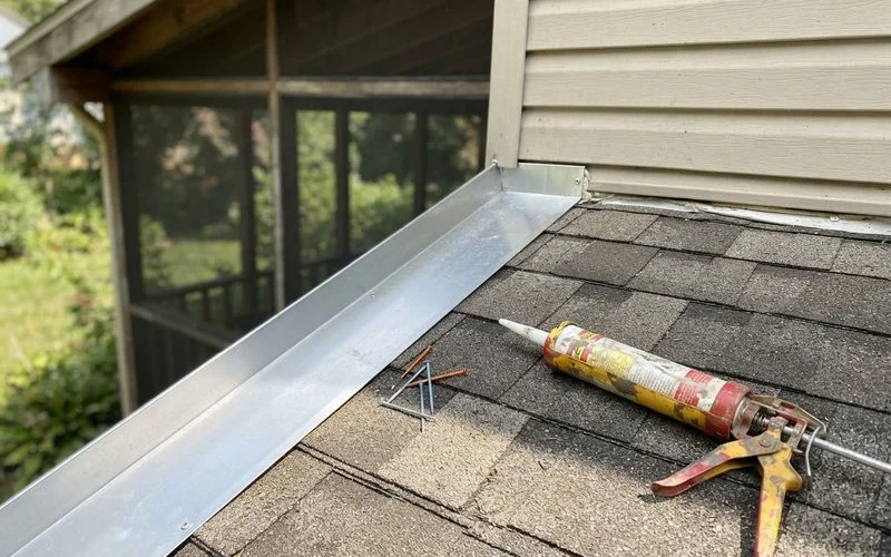 A screened porch roof line where it connects to the main house, showing flashing details along the joint
